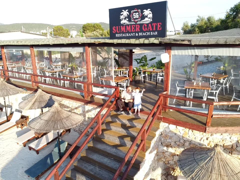 Wooden entrance and sign of Summer Gate restaurant in Ksamil