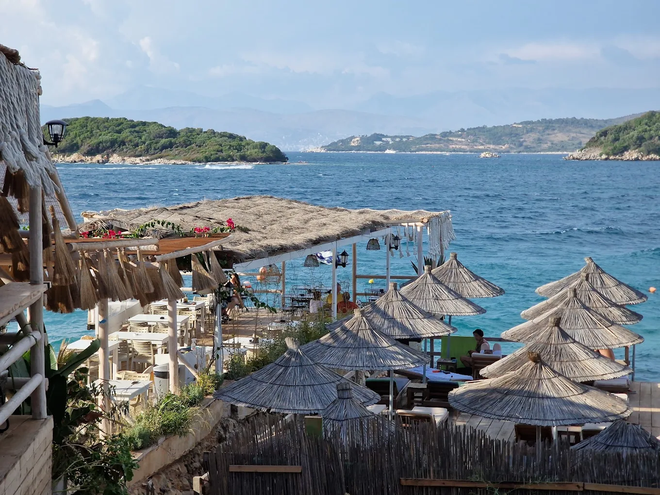 View of Ksamil bay from a bamboo-roofed beach deck at Summer Gate