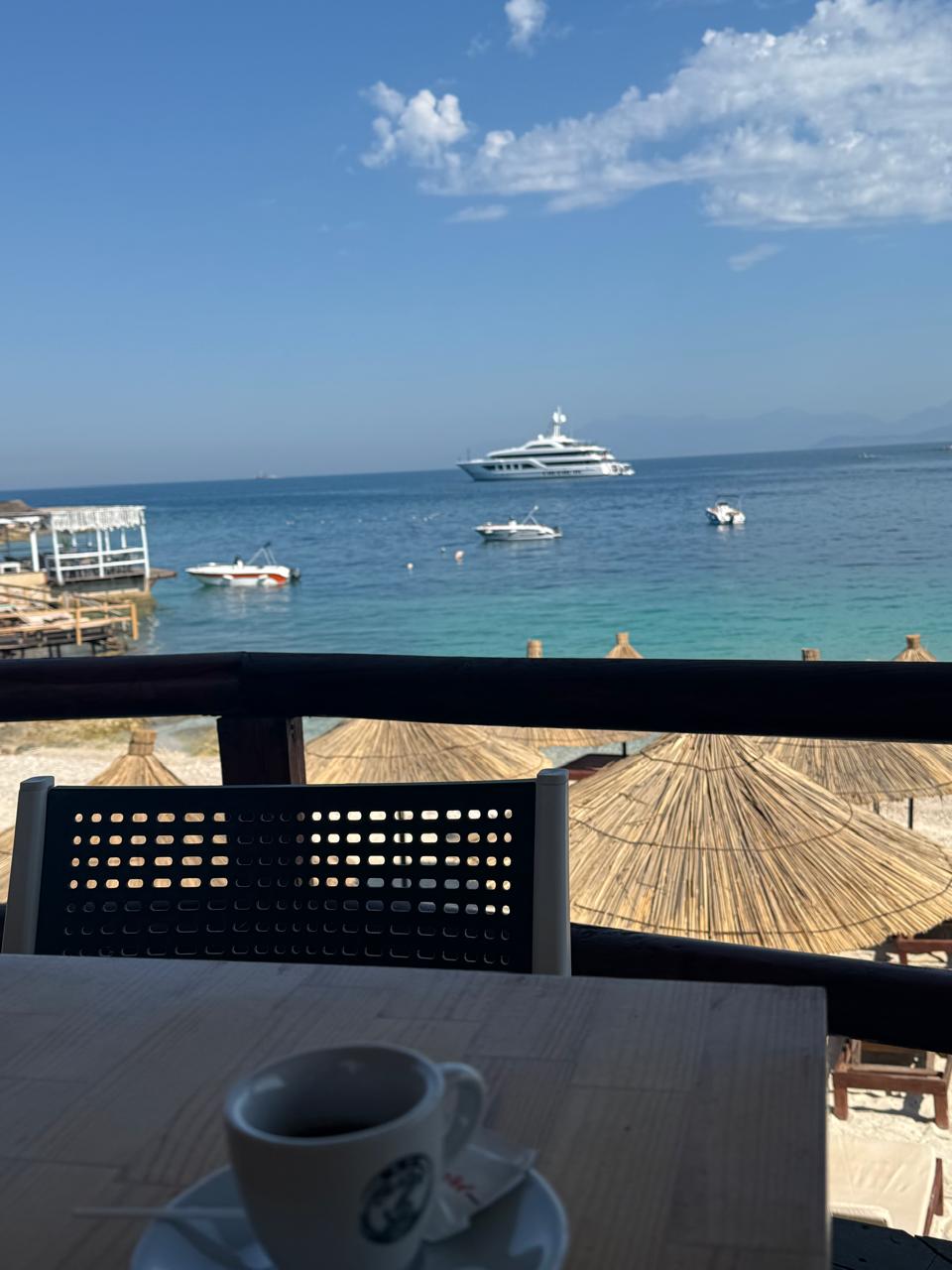 Reed umbrellas lining the Ksamil shore at Summer Gate beach club
